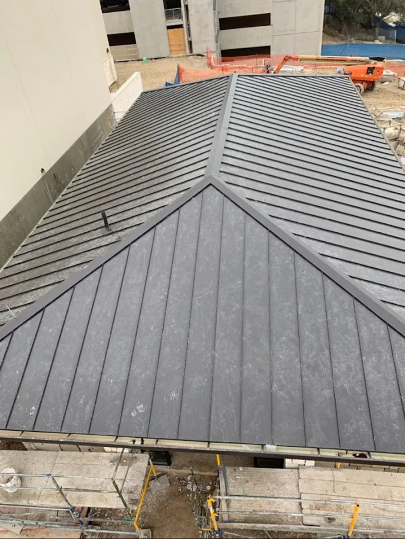 Commercial metal roof construction with crane equipment in Four Corners